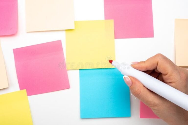 mano escribiendo con marcador sobre sticker colorido