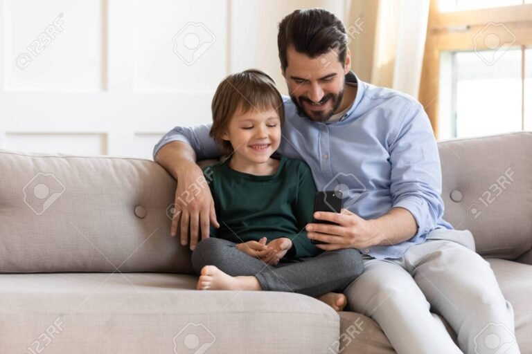 Cómo Saber Cuánto Cobro de AUH y Cuándo Me Depositan 17 nino feliz con padre revisando celular