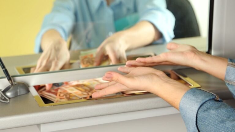 persona cobrando dinero en ventanilla bancaria