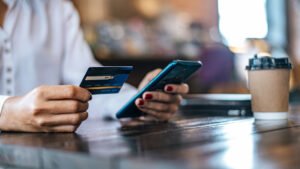 persona usando celular y tarjeta de credito 1