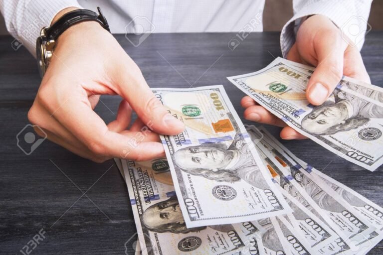 reloj y manos entregando dinero efectivo